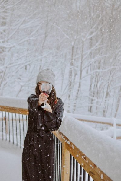 woman in black coat standing on snow covered ground during daytime