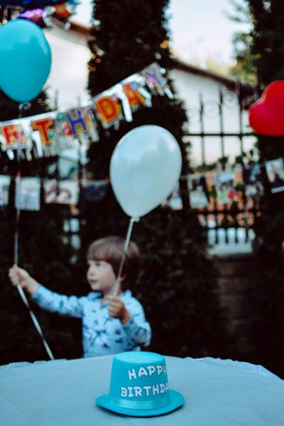 boy holding blue and white balloons at the party