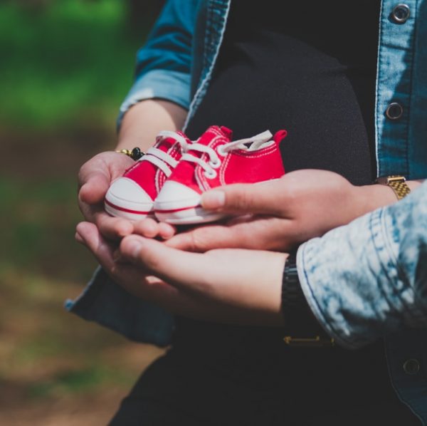 person holding white and red heart ornament