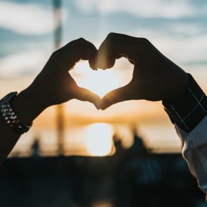 person forming heart with their hands