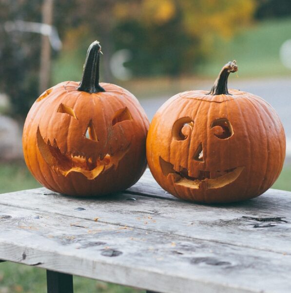 two pumpkins on brown wooden table