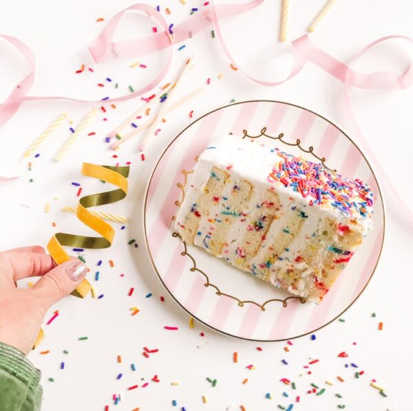 person holding white and pink floral ceramic plate