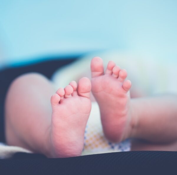 shallow focus photography of baby wearing white diaper lying