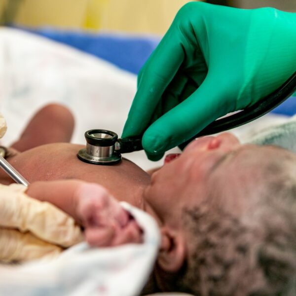 person in teal long sleeve shirt lying on bed