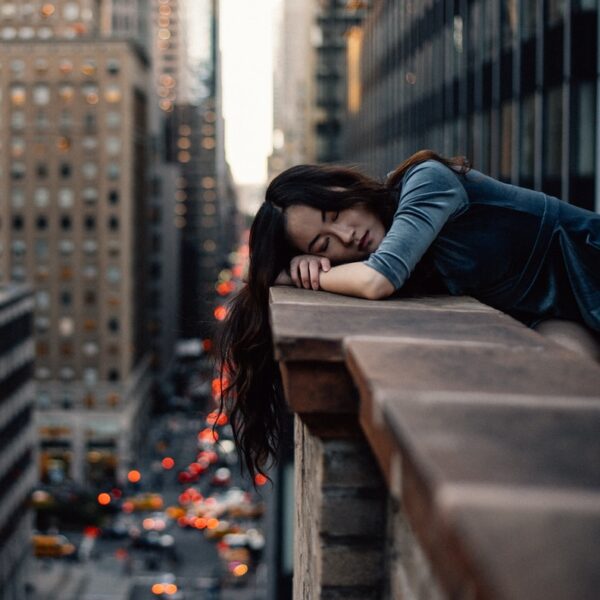 woman leaning on top building rail during daytime