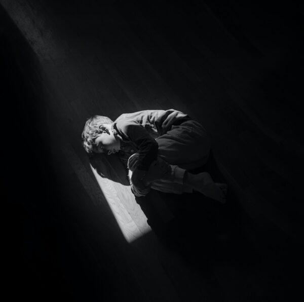 man in black jacket and pants sitting on stairs