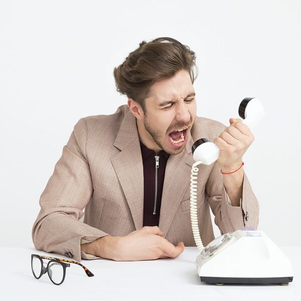 man holding telephone screaming