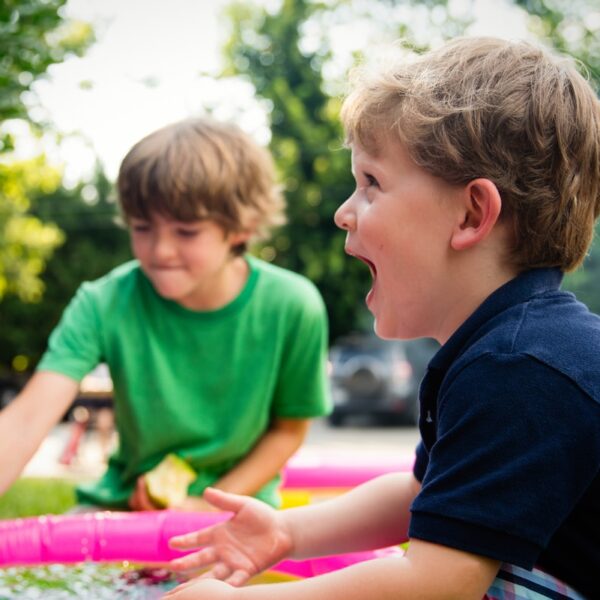boy in blue shirt screaming near boy in green crew-neck shirt