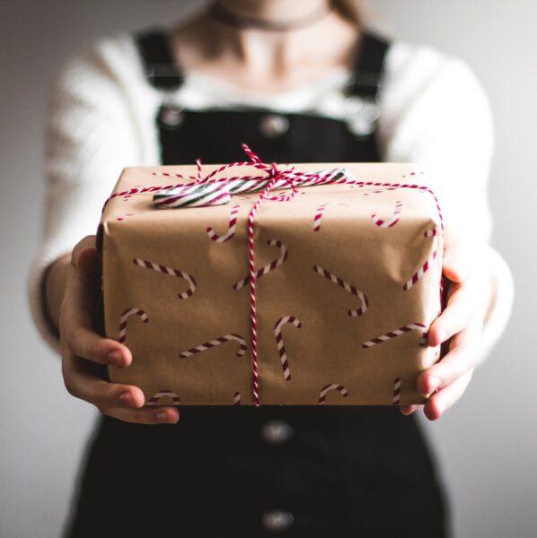 person showing brown gift box