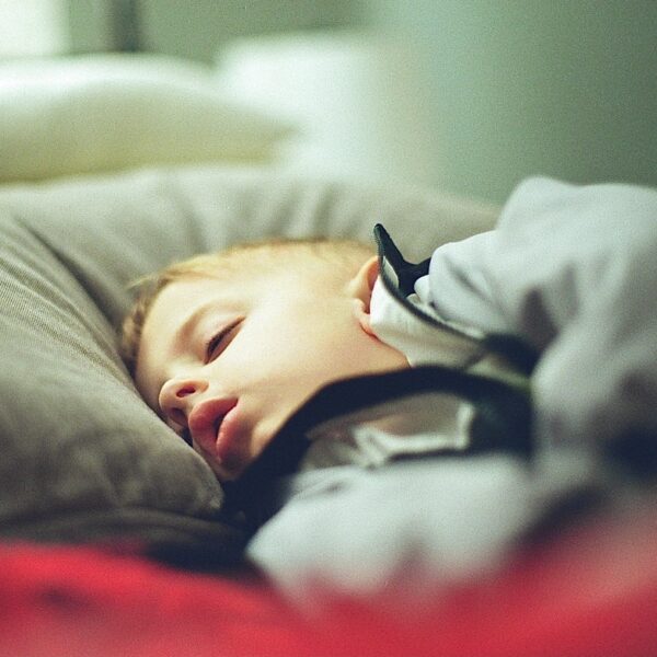boy in white and black hoodie lying on bed