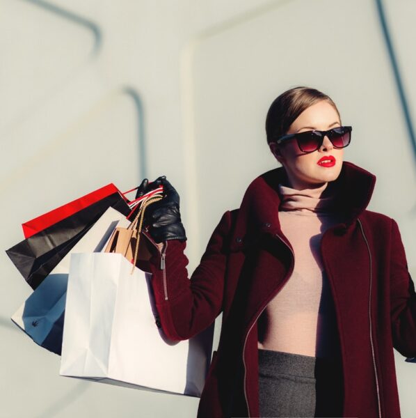 photo of woman holding white and black paper bags
