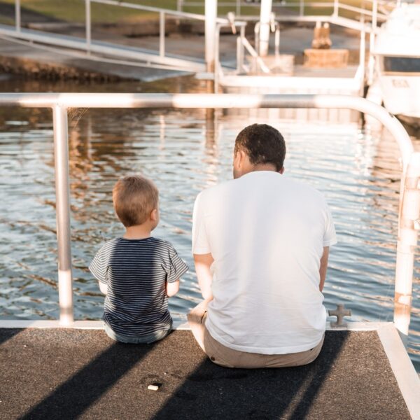 man and boy sitting on dock