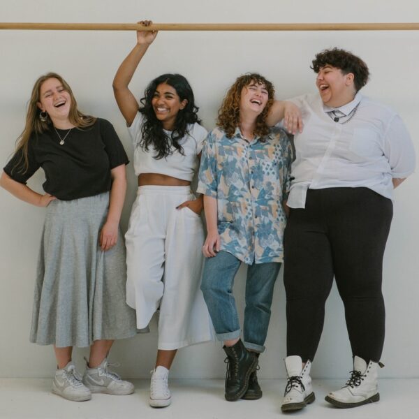 four person standing beside wall