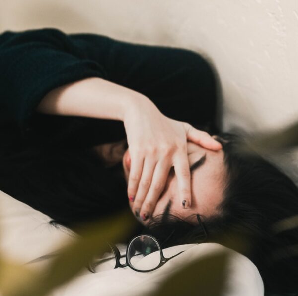 woman in black long sleeve shirt covering her face