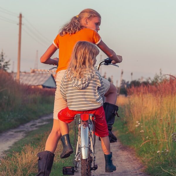 woman in white and black stripe dress riding on red motorcycle during daytime