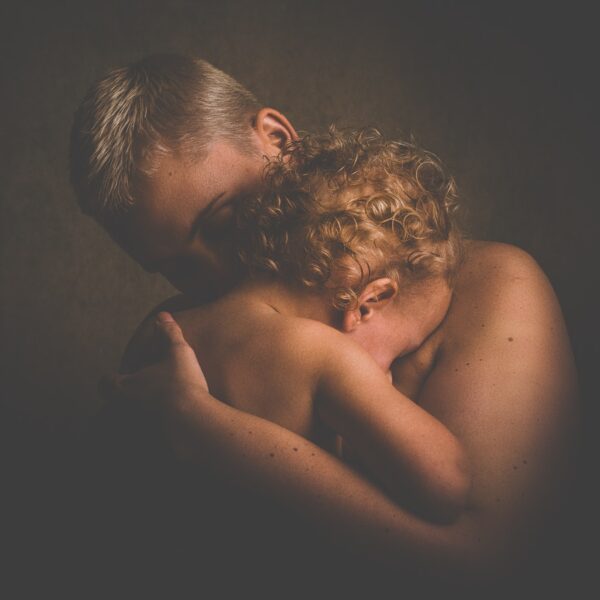 topless person carrying children