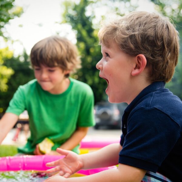 boy in blue shirt screaming near boy in green crew-neck shirt