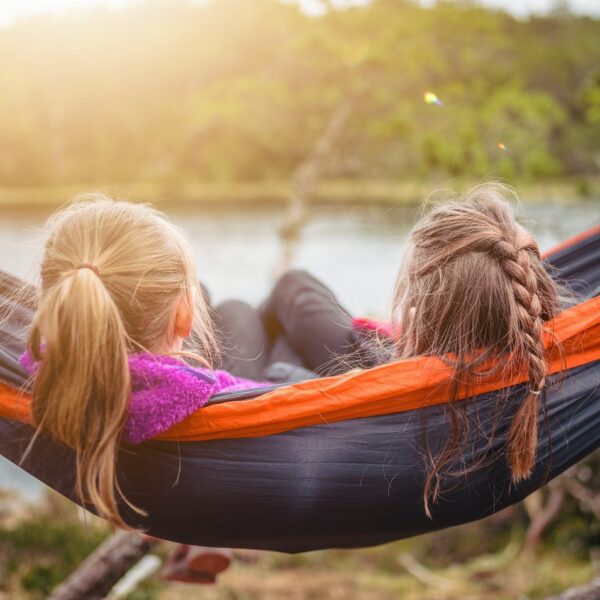 two women lying on hammock