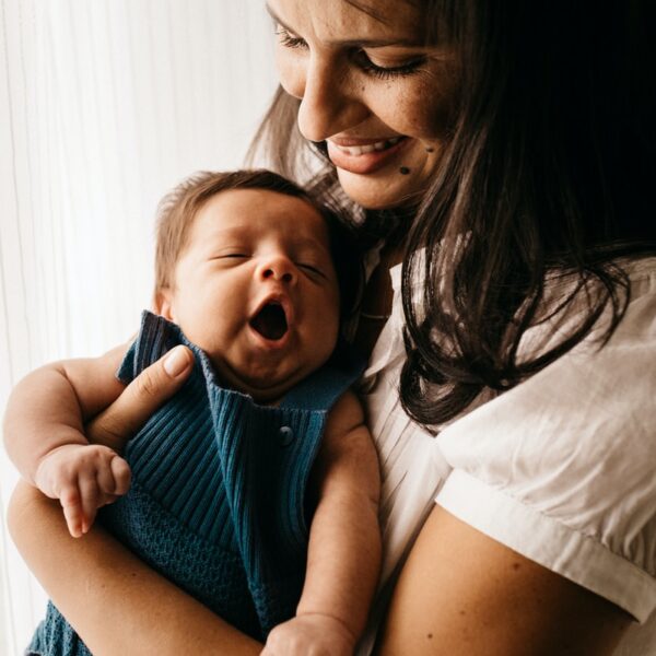 woman in white shirt carrying girl in blue shirt