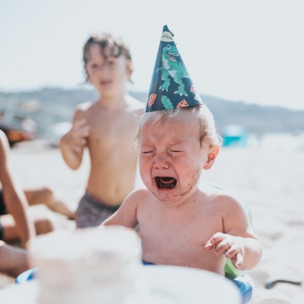 topless boy in blue and white floral shorts sitting on white and blue inflatable pool during