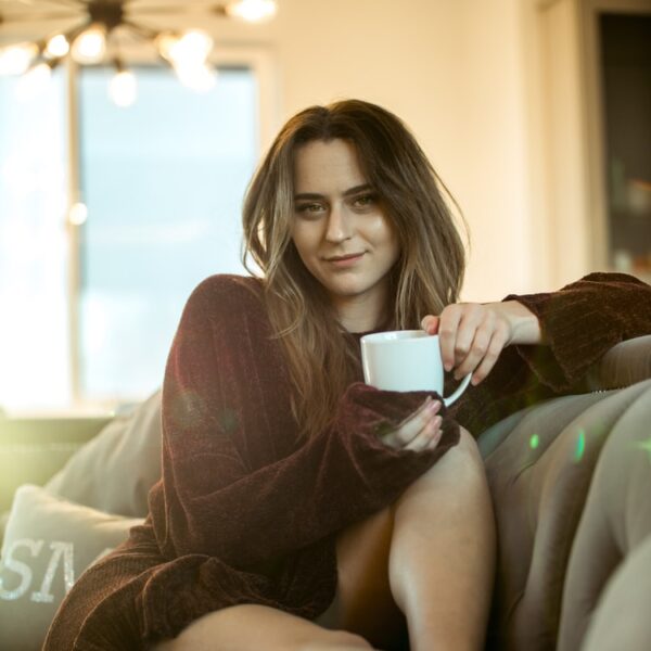 woman wearing maroon sweater sitting on sofa