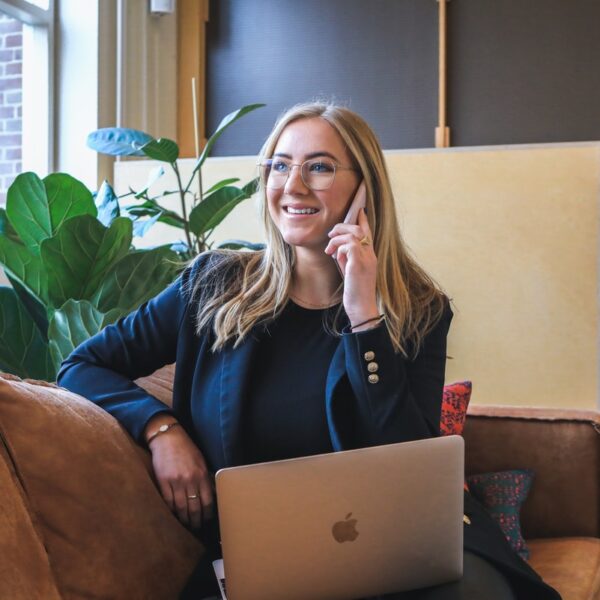 woman in blue long sleeve shirt using silver macbook
