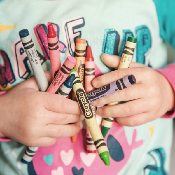 toddler holding assorted-color Crayola lot