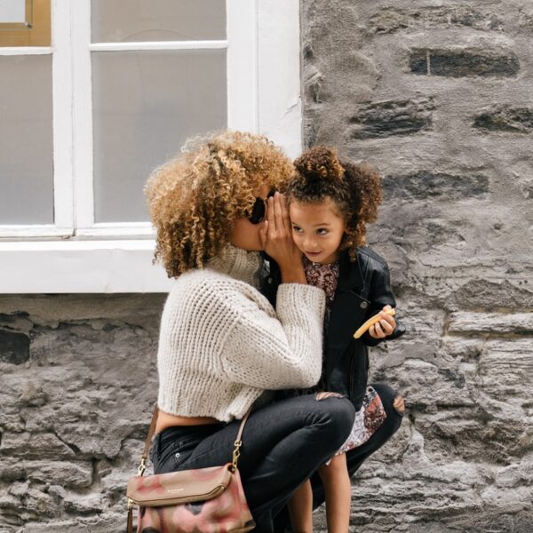 woman wearing white sweater carrying a daughter