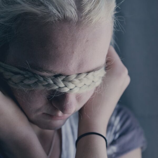 woman covering eyes using braided hair