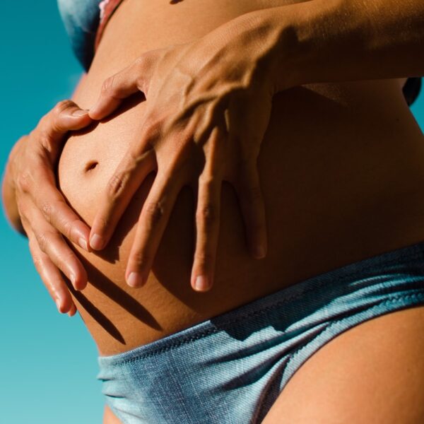 closeup photography of pregnant woman wearing blue panty