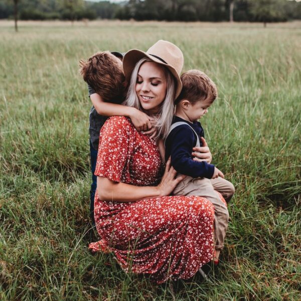 man and two children on grass field