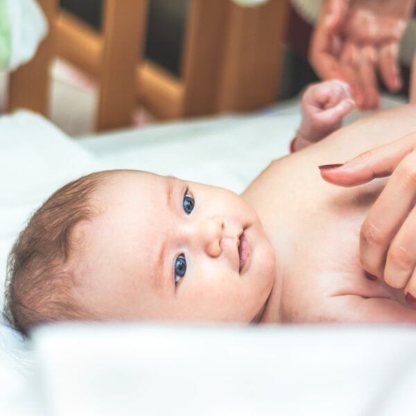 baby lying in white textile