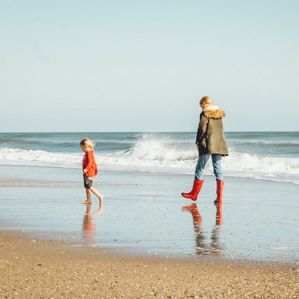 woman and child standing on seashore