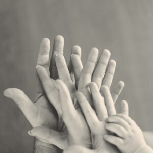 grayscale photo of family's hands