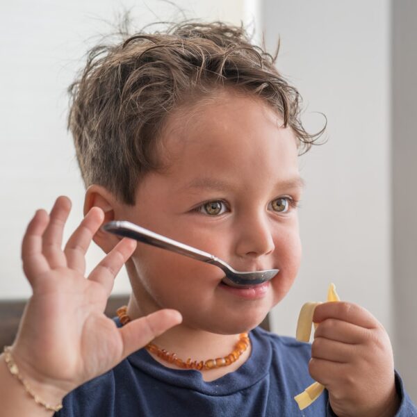 girl in blue crew neck shirt holding silver pen