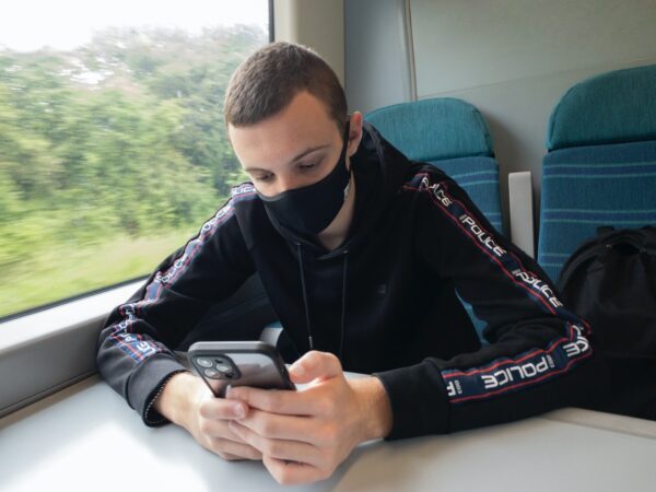 a person sitting on a train looking at the phone