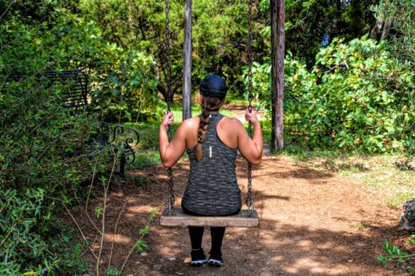 a woman on a swing in the woods