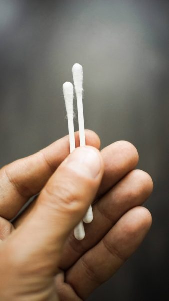a person holding two toothbrushes in their hand